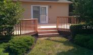 A wide set of steps leads up the deck and to the sliding glass door to the home