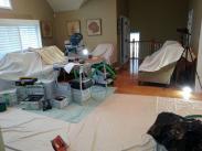 Furniture stays covered to protect it from dust and drop cloths are laid down to protect the existing hardwood flooring