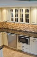 Appliances are tucked away neatly and glass front cabinets add an elegant touch