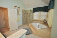 View from the half wall into this roomy and functional master bathroom by Drumm Design Remodel