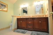 Great view of the cabinetry and decorative tile element that mirrors the design over the corner tub