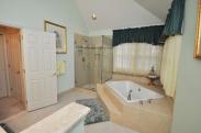 The bathroom added a beautiful glass enclosed shower and roomy step up corner bathtub