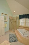 View of the sloped ceilings and can light over the glass enclosed shower