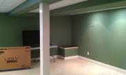 The owners get ready to set up the big screen TV in their new basement space