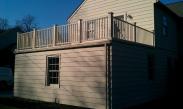 A view from the rear of the home with the new railing by Drumm Design Remodel
