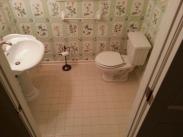 A view of the tile and powder room before Drumm Design Remodel