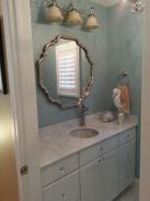 The vanity, under mounted sink, new decorative mirror and lighting by Drumm Design Remodel