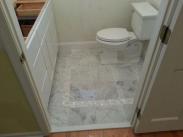 Custom tile work in this powder room is a specialty of Drumm Design Remodel