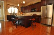 New flooring, a center island, new lighting and granite countertops were all part of this wonderful kitchen remodel by Drumm Design Remodel