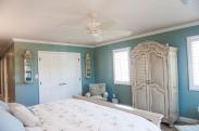A view of this master bedroom by Drumm Design Remodel with the closet doors closed to show off the hardware and trim work